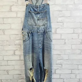 Distressed blue denim overalls on display