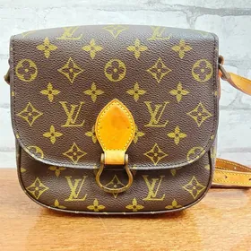 Brown monogram shoulder bag with a tan leather clasp